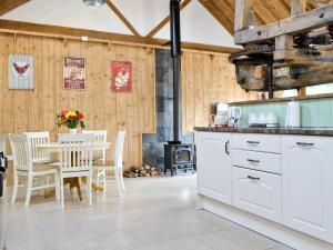 a kitchen with white cabinets and a table and chairs at The Chaff House in Arlingham