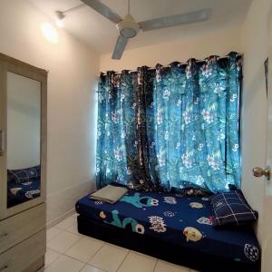 コタキナバルにあるComfy UUC Homestay Bajet Kota Kinabaluのベッドルーム1室(青いカーテン付きのベッド1台付)