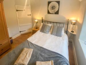 sypialnia z łóżkiem z niebiesko-białymi poduszkami w obiekcie Old Tan Rhiw w mieście Beddgelert