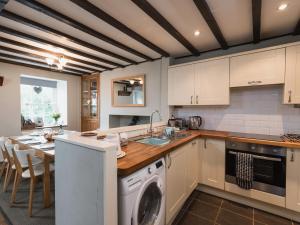 una cocina con lavadora y secadora junto a una mesa en Old Tan Rhiw, en Beddgelert