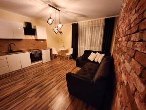 a living room with a couch and a brick wall at Apartament P&P Prestige II in Inowrocław