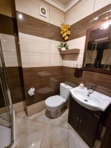 y baño con aseo y lavamanos. en Apartament P&P Prestige II en Inowrocław