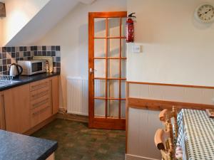 a kitchen with a counter and a cabinet in it at Ffron Erch Cottages - 2712 in Llanarmon