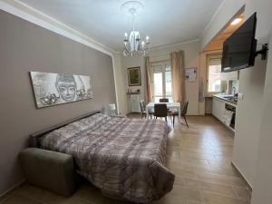 a bedroom with a large bed and a dining room at ATTICO BRICCARELLO -Intero Appartamento- Elegant Suite with FREE WIFI near PalaAlpitour and Sporting Club Torino-Olimpyc Stadium in Turin