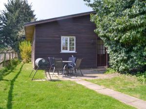 una mesa y sillas frente a una casa en The Cottage - B4014, en Wendling