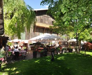 a group of people sitting at tables in a park at Gasthof Lamm in Matrei am Brenner