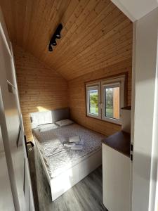 małą sypialnię z łóżkiem w drewnianym pokoju w obiekcie RYBY W SIECI we Władysławowie