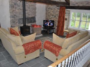 a living room with two chairs and a television at 2 Seed Howe in Staveley