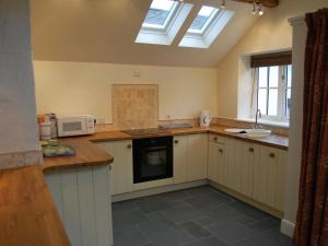 a kitchen with white cabinets and a skylight at 2 Seed Howe in Staveley