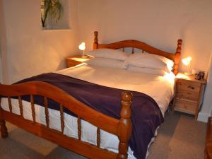 a bedroom with a large wooden bed with pillows at 2 Seed Howe in Staveley