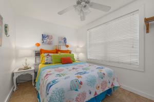 1 dormitorio con 1 cama y ventilador de techo en Cottage C, en Flagler Beach
