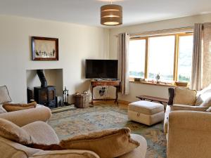 a living room with couches and a fireplace and a television at Mountain View in Tomintoul