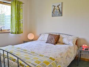 a bedroom with a bed with a comforter and a window at Mountain View in Tomintoul