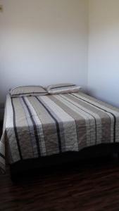 a bed with a striped blanket on top of it at PUNTA NEGRA DISFRUTABLE TODO EL AÑO! in Punta Colorada +4 photos