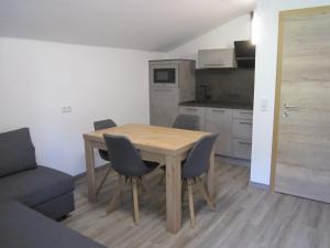 eine Küche mit einem Holztisch und Stühlen im Zimmer in der Unterkunft Haus Kohlbründl in Saalbach-Hinterglemm