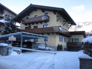 ein großes Gebäude mit viel Schnee davor in der Unterkunft Haus Kohlbründl in Saalbach-Hinterglemm