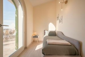 een woonkamer met een bank naast een raam bij Villa Teti in San Vincenzo