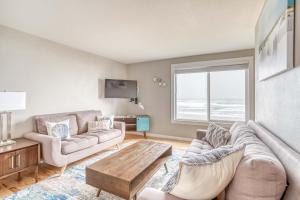 洛克威海灘的住宿－Whale Watcher Condo #3，客厅配有沙发和桌子