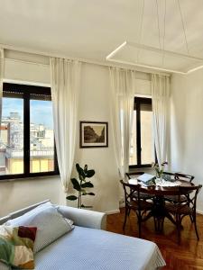 um quarto com uma mesa, uma cama e janelas em #FASHIONWEEK Private Room in Brera District em Milão
