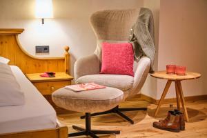 a bedroom with a chair with a pink pillow on it at Hotel Waldhaus Föckinghausen in Bestwig