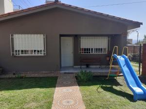 una pequeña casa con un tobogán y un parque infantil en Santa Rita en Villa Carlos Paz