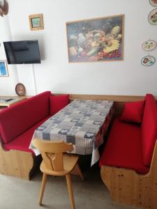 - un salon avec un canapé rouge et une table dans l'établissement Tana delle Marmotte, à Falcade