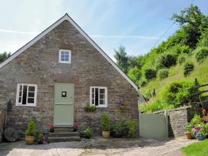 una piccola casa in mattoni con una porta verde di Anvil Cottage a Blakeney
