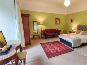 a bedroom with a bed and a red couch at Whitehall Pele Tower in Mealsgate