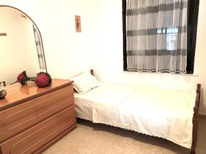 ein Schlafzimmer mit einem Bett, einem Spiegel und einer Kommode in der Unterkunft Beautiful Beach Appartment Vicky, Ofrynio Beach in Ofrynio
