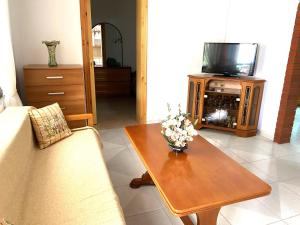 ein Wohnzimmer mit einem TV und einem Couchtisch in der Unterkunft Beautiful Beach Appartment Vicky, Ofrynio Beach in Ofrynio
