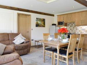 a kitchen and living room with a wooden table and chairs at The Cartshed in Knaresborough