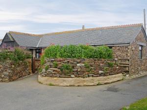a stone retaining wall in front of a house at The Old Stable in Holywell Bay