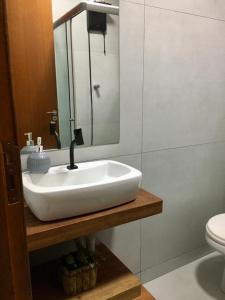 a bathroom with a white sink and a toilet at Casa de campo com piscina in Jaguariaíva