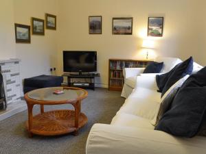 a living room with a couch and a tv at Whitegates in Portinscale