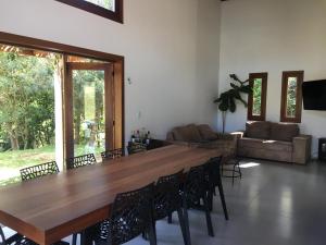 una gran mesa de madera y sillas en la sala de estar. en Casa de campo com piscina en Jaguariaíva