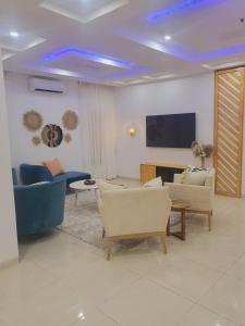 un soggiorno con divani e TV a schermo piatto di The Private Apartments: 2-Bedroom & 3-Bedroom a Port Harcourt
