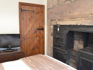 シーハウシズにあるThe Coracleの木製のドアと暖炉付きのベッドルーム1室
