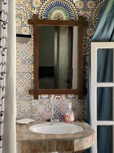 a bathroom with a sink and a mirror at Essaouira Youth Hostel & Social Travel in Essaouira