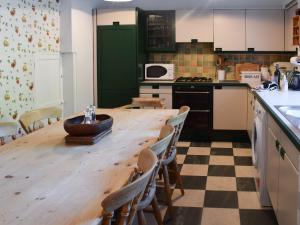 een keuken met een houten tafel en stoelen bij Oakghyll in Windermere