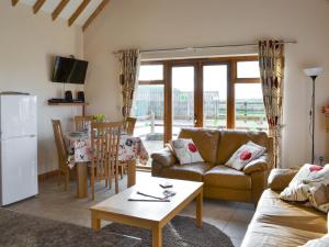 a living room with a couch and a table at Kingfisher Cottage - 25114 in Flamborough
