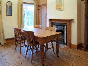 a wooden table and chairs in a room with a fireplace at Jennys Cottage 27553 in Mundesley