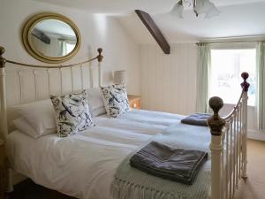 a bedroom with a white bed with a mirror at Jennys Cottage 27553 in Mundesley
