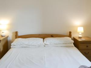 a bed with two white pillows and two lamps at Kingfisher Cottage - 25114 in Flamborough