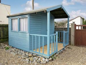 a blue out house sitting on a pile of rocks at Jennys Cottage 27553 in Mundesley