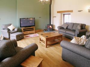 a living room with couches and a flat screen tv at Bram Crag Barn in Legburthwaite