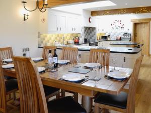 a kitchen with a wooden table with chairs and a dining room at Bram Crag Barn in Legburthwaite