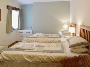 a bedroom with two beds and a chair at Bram Crag Barn in Legburthwaite