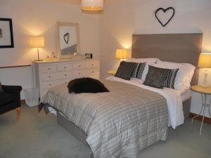 1 dormitorio con 1 cama con tocador y espejo en The Old Woodyard, en Kendal
