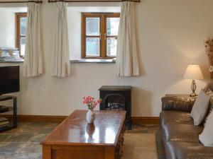 a living room with a couch and a coffee table at Apple Tree Cottage -18512 in Kilkhampton