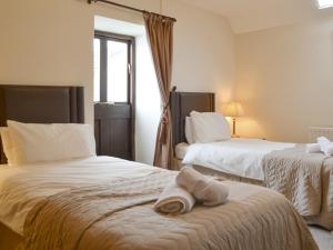 a hotel room with two beds with towels on the bed at The Stables - 24971 in Frosterley